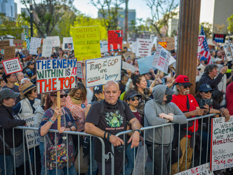 4/5/25 - Los Angeles, Calif: Thousands of protestors sit across barriers as they look up at the Los Angeles City Hall on April 5 during the "Hands Off" protest. Photo Credit: Justin Enriquez