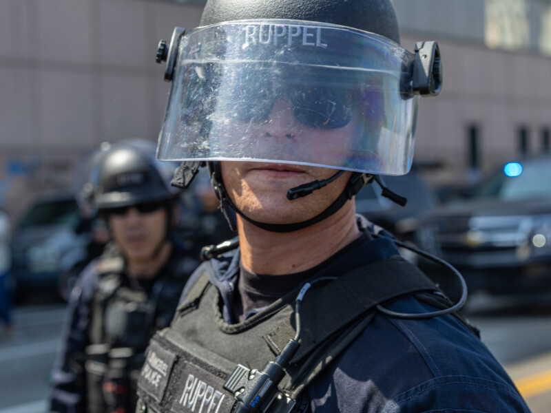 A police officer in riot gear forms part of the law enforcement line as protestors confront them screaming numerous expletives on June 8. The anti-ICE protest was declared an "unlawful assembly" and police began to disperse the crowds. Ethan Cohen | Long Beach Current